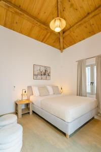 a bedroom with a large bed and a wooden ceiling at Sarakina Urban Grace in Stone by 8essentially in Heraklio