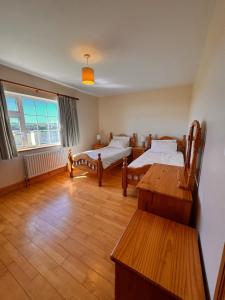 a room with two beds and a table in it at Beach Side House in Quilty in Quilty