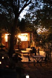 a group of benches and tables in a yard at night at Kalemi Pansiyon in Marmara