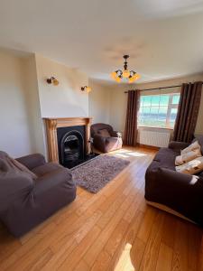 a living room with a couch and a fireplace at Beach Side House in Quilty in Quilty