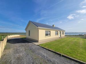 a small house on the side of a road at Beach Side House in Quilty in Quilty