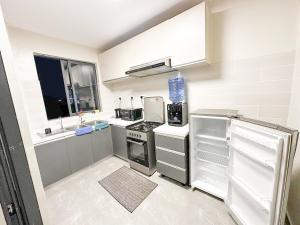 a small kitchen with white appliances and a window at Two-Bedroom Apartment Near JKIA & SGR Free Parking & Wi-Fi By Irene in Nairobi