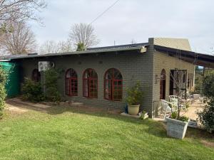 a brick house with red windows and a yard at 19 on Amber in Ugie