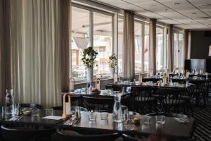 a dining room with tables and chairs and windows at Selma Spa in Sunne