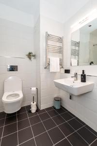 a white bathroom with a toilet and a sink at Wee Sleep Ireland in Derry Londonderry