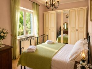 a bedroom with a large bed with a green blanket at Holiday House Nemi in Monte Porzio