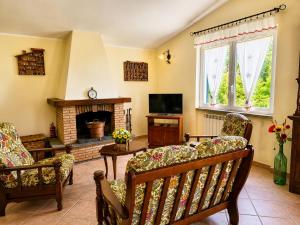 a living room with two chairs and a fireplace at Holiday House Nemi in Monte Porzio