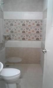 a bathroom with a toilet and a sink and a shower at Hotel Ella Tambolaka in Tambolaka Airport +6 photos