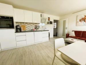 a kitchen with white cabinets and a living room at Ferienhaus "Christin" Objekt-ID 15689-2 in Waren