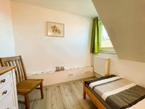 a bedroom with a bed and a chair and a window at Ferienhaus "Christin" Objekt-ID 15689-2 in Waren +9 photos