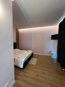 a bedroom with a bed and a wooden floor at Gwin Hotel in Fier