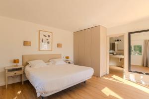 a bedroom with a large white bed and a mirror at Villa Can Ferrer in the centre of Cala dOr in Cacla D'or +17 photos