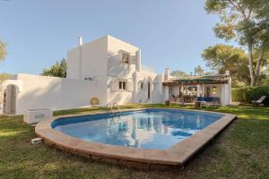 a large pool in front of a white house at Villa Can Ferrer in the centre of Cala dOr in Cacla D'or