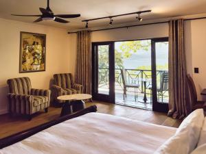 a bedroom with a bed and a balcony at Harties Lake View in Hartbeespoort
