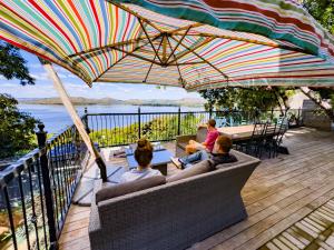 a group of people sitting on a couch under an umbrella at Harties Lake View in Hartbeespoort