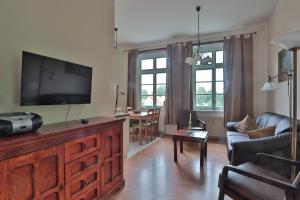 a living room with a flat screen tv and a couch at Herrenhaus Blengow App.08 in Blengow +14 photos