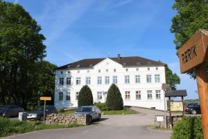 a white house with a car parked in front of it at Herrenhaus Blengow App.08 in Blengow