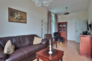 a living room with a brown leather couch and a table at Herrenhaus Blengow App.08 in Blengow