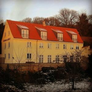 カロンボーにあるHotel Ole Lunds Gaardの黄色の大屋根