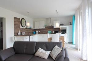 a living room with a couch and a kitchen at Maison du Bonheur in Rerik
