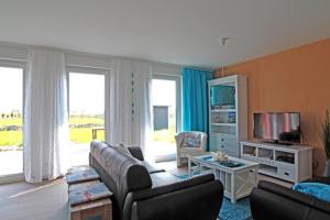a living room with a couch and a tv at Maison du Bonheur in Rerik