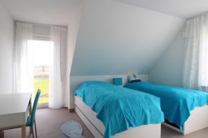 a bedroom with two beds and a table and a window at Maison du Bonheur in Rerik