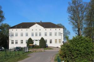 a large white building with a road in front of it at Maison du Bonheur in Rerik