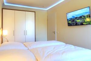 a bedroom with two beds and a flat screen tv at Warnemünde Meeresrauschen 21707 in Warnemünde +13 photos