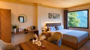 a bedroom with a bed and a large window at The Woodnest Tandi in Jibhi