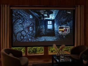 a large flat screen tv in a living room at The Woodnest Tandi in Jibhi
