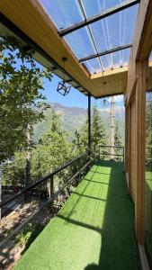 a balcony of a house with a view of the mountains at The Woodnest Tandi in Jibhi