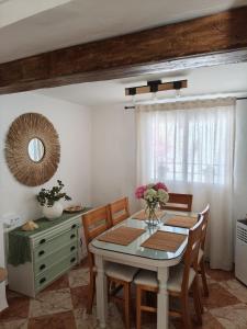 a dining room with a table and chairs and a mirror at Casa Rural Hortensia in Zuheros