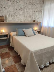 a bedroom with a large white bed with two lamps at Casa Rural Hortensia in Zuheros +45 photos