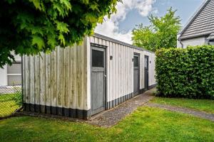a wooden building with a fence in a yard at Lontargos OG Wohnung in Göhren-Lebbin