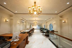 a large room with tables and chairs and a chandelier at Shree Anantay Club & Resort in Ujjain