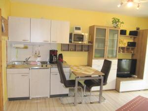 a kitchen with a table and chairs and a television at Apartment Abendstille mit Balkon und TG in Bamberg