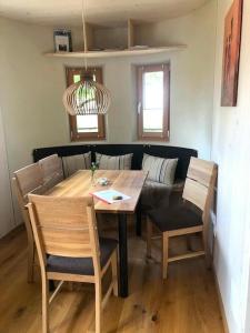 a dining room with a table and chairs and a couch at Tiny House Hubert von Auernheim in Treuchtlingen +6 photos