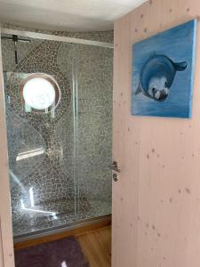 a bathroom with a glass shower with a dolphin on the wall at Tiny House Hubert von Auernheim in Treuchtlingen