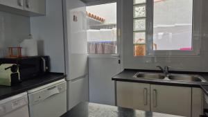 a kitchen with a sink and a microwave at villaislandia in Oropesa del Mar