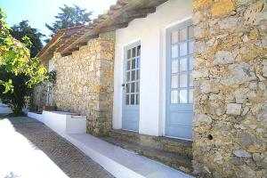 a building with a blue door and a stone wall at Senhora do Cabo Meco Homy Holidays in Sesimbra