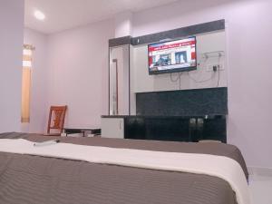 a bedroom with a bed and a tv on a wall at GM Residency in Velankanni