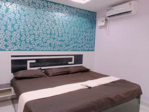 a bedroom with a bed with a blue wall at GM Residency in Velankanni +23 photos