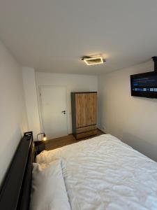a bedroom with a large bed and a wooden cabinet at Main Panorama Suite 97896 Freudenberg in Freudenberg am Main