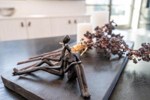 a statue of a man sitting on a table with a centerpiece at Reetidyll am Haff - Haus 2 in Stolpe auf Usedom