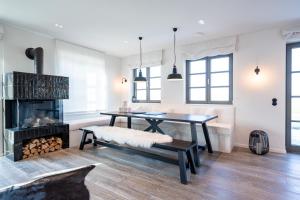 a dining room with a table and a fireplace at Reetidyll am Haff - Haus 2 in Stolpe auf Usedom