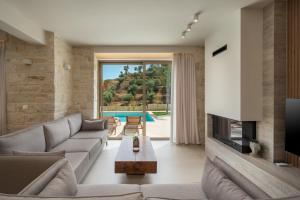 a living room with a couch and a fireplace at La Divina Luxury Villas with Heated Pool in Daratso
