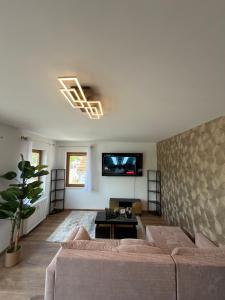 a living room with a couch and a tv on a wall at Main Panorama Suite 97896 Freudenberg in Freudenberg am Main