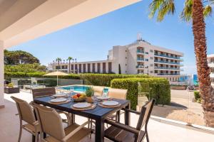 a table and chairs on a patio with a view of a building at Villa Camomila Tomas by Villa Plus in Santo Tomás