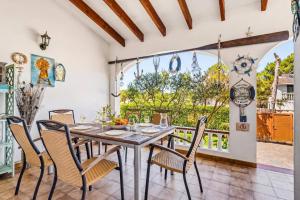 a dining room with a table and chairs and a balcony at Villa Tamyan by Villa Plus in Son Parc