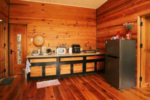 a kitchen with a refrigerator in a log cabin at À La Main Farmhouse in Ấp Trường Sơn